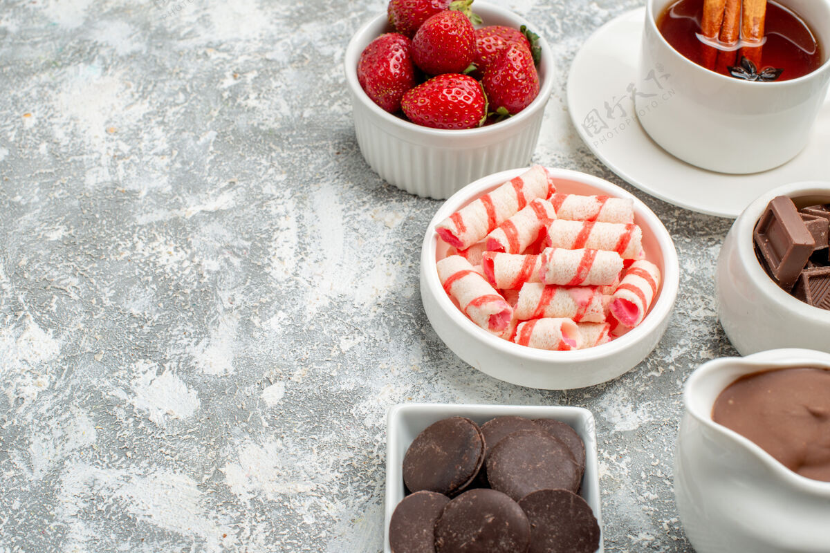 甜点底部近距离观看碗与可可糖果草莓巧克力茶肉桂在灰白色的桌子右侧与自由空间碗健康食物