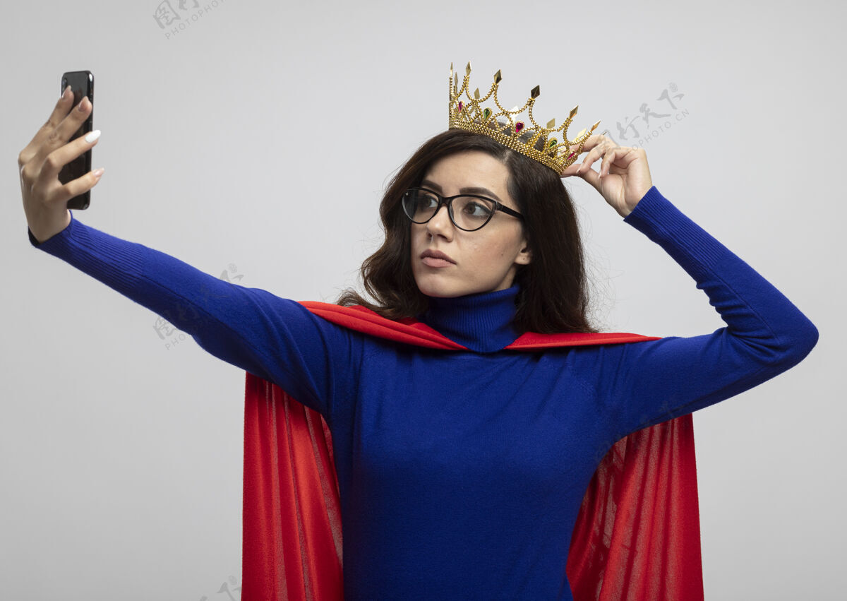 皇冠自信的白种人超级英雄女孩戴着一副眼镜 头上戴着一顶王冠电话信心光学