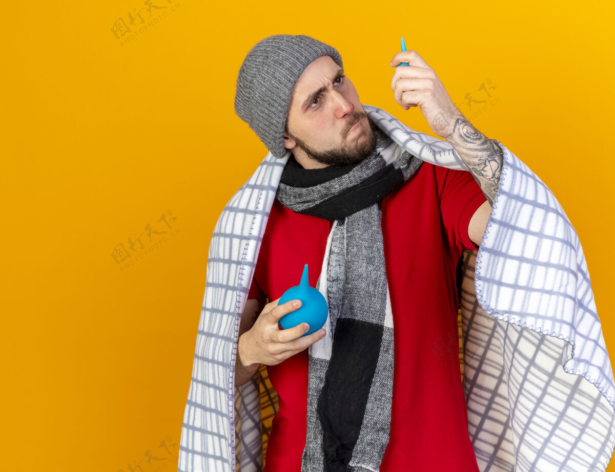 冬天严肃的年轻白种人 戴着冬天的帽子 围着方格布围巾疾病男人穿