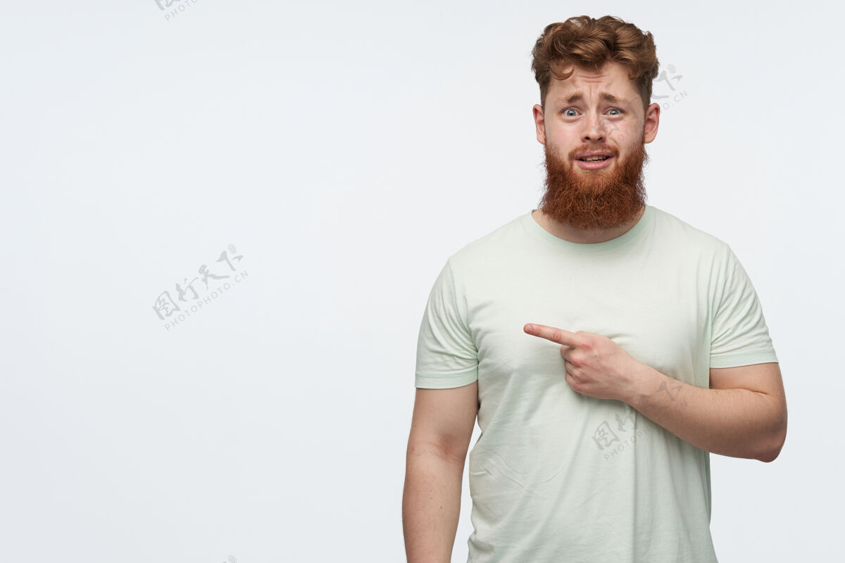 模特一个满头红发 留着胡须的糊涂男人穿着一件指向左边的空白t恤男人休闲厌恶