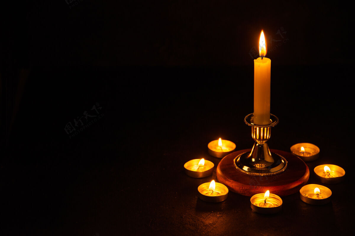 风景燃烧的蜡烛的正面视图 作为坠落黑暗表面的记忆燃烧倒下烛台