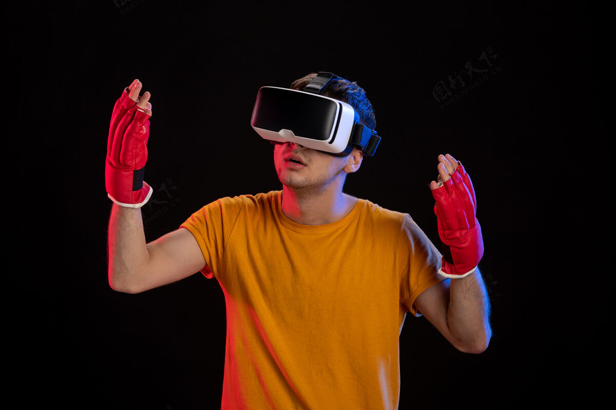 肖像年轻男性玩虚拟现实在mma手套上的黑暗桌面游戏d科技视觉Mma游戏现实