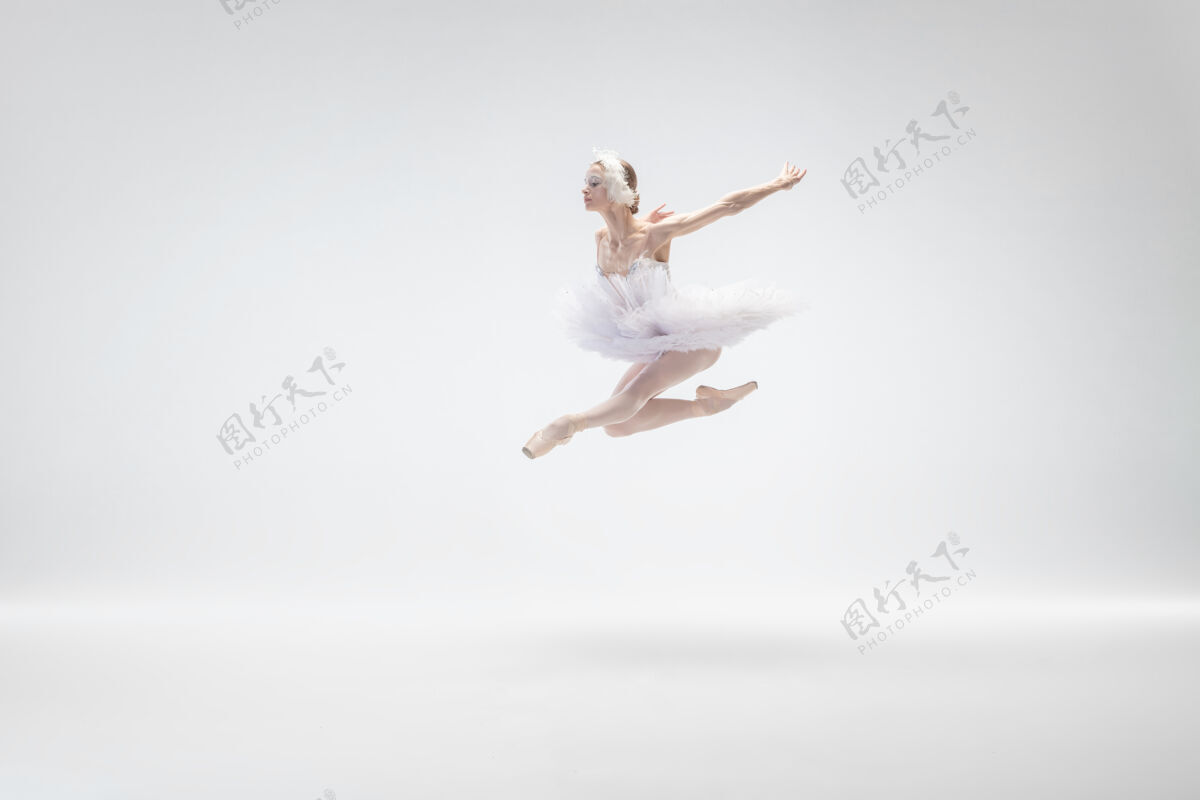当代以白色工作室为背景的年轻优雅的芭蕾舞演员年轻喜悦动作