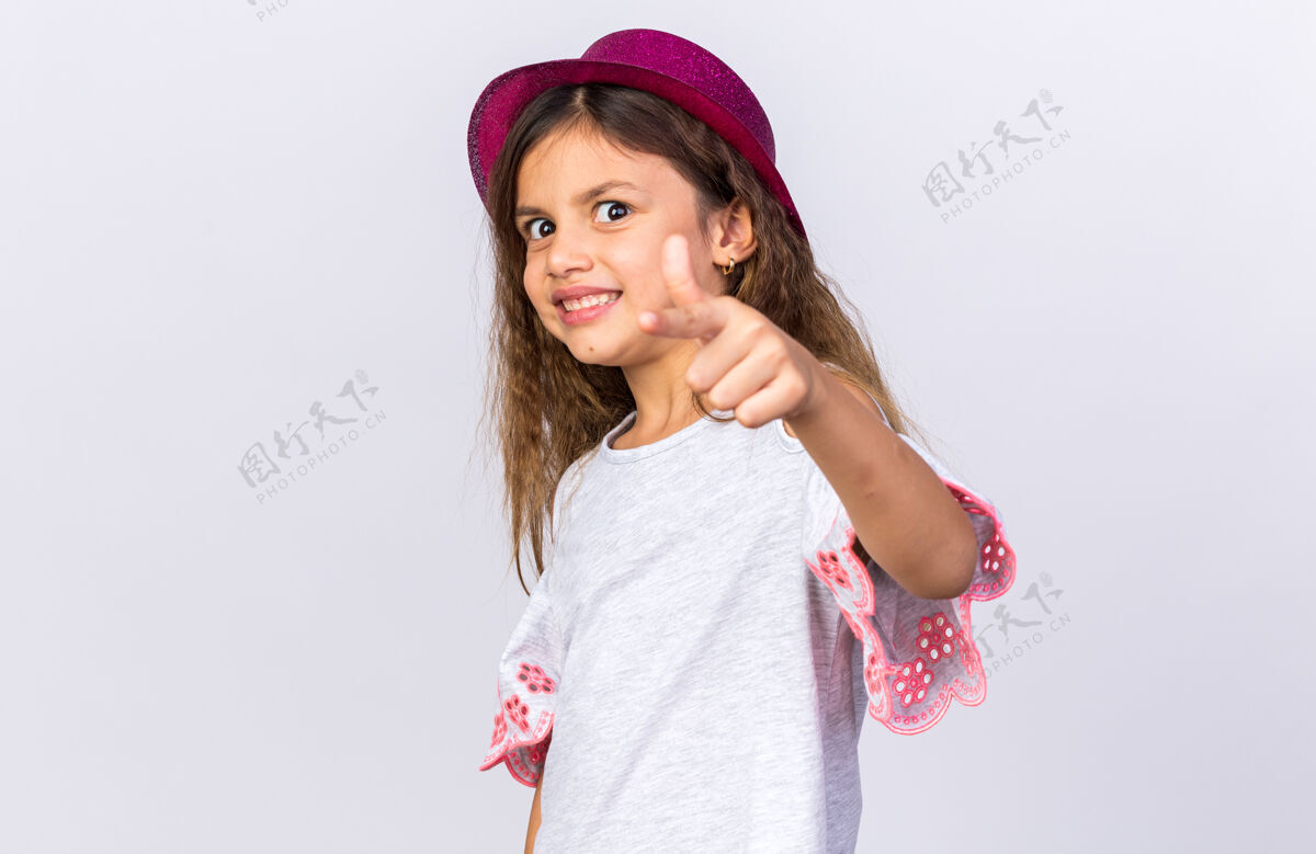白种人微笑着的白人小女孩 戴着紫色派对帽 孤立地站在白色墙壁上 留着复制空间小派对生日