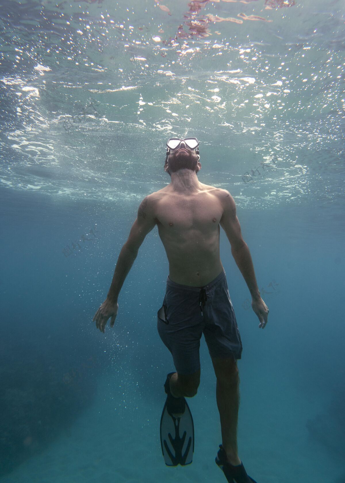 潜水戴着潜水器的人在海里游泳垂直游泳水上
