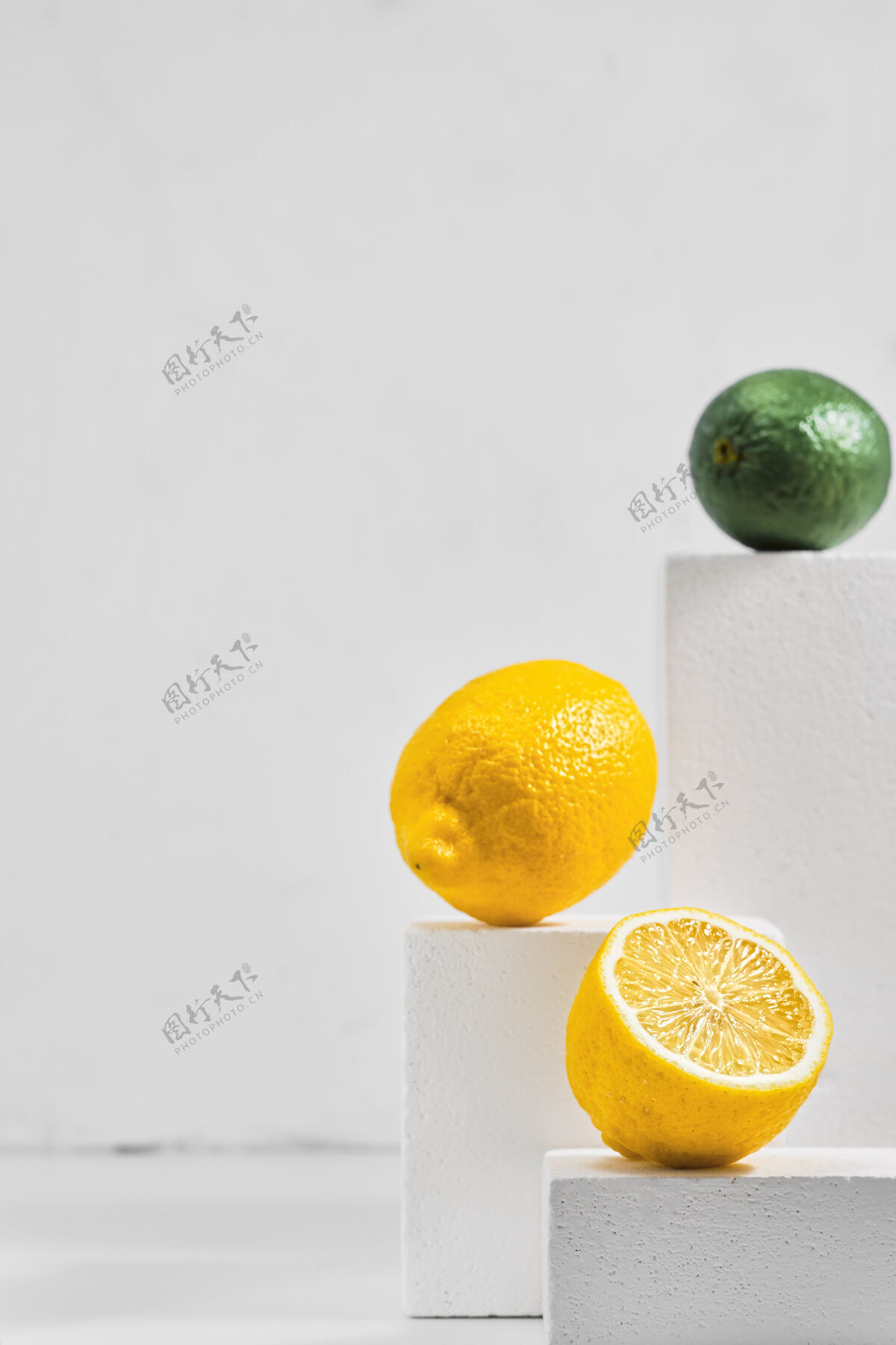 浅色新鲜的柠檬和酸橙放在灰色的桌子上 柑橘类水果的简约概念黄色灰色酸橙