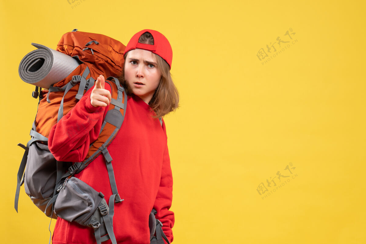 前面正面图：穿着红色背包的年轻女旅行者指着我背包成人帽子
