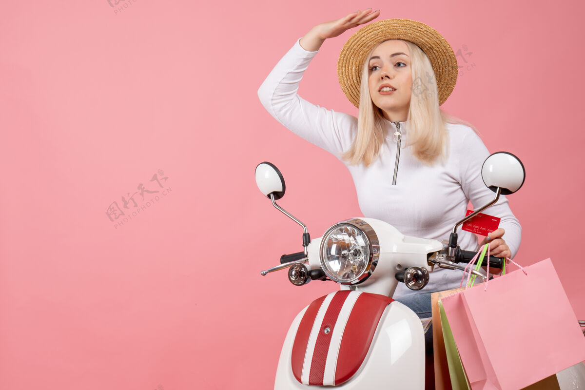 年轻女士前视图：骑着轻便摩托车的年轻女士 带着购物袋匆匆忙忙衣服轻便摩托车快点