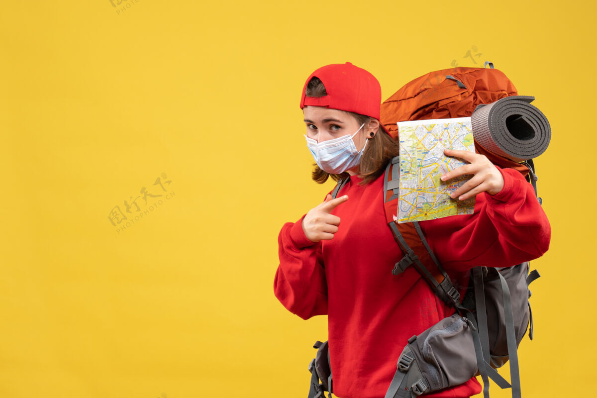 前面正面图年轻的女旅行者带着背包和面具拿着地图背包面具地图