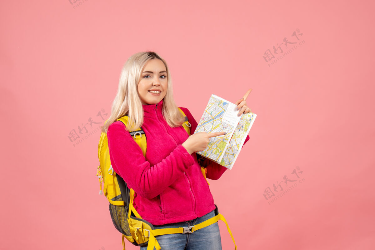 成人正面图：一个女人背着黄色的背包 拿着地图指向右边背包女士地图