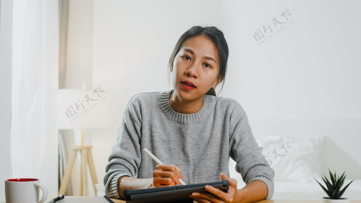 讨论年轻的亚洲女商人在卧室的家里工作时 用笔记本电脑在视频电话会议上和同事谈论计划自由职业者聊天会议