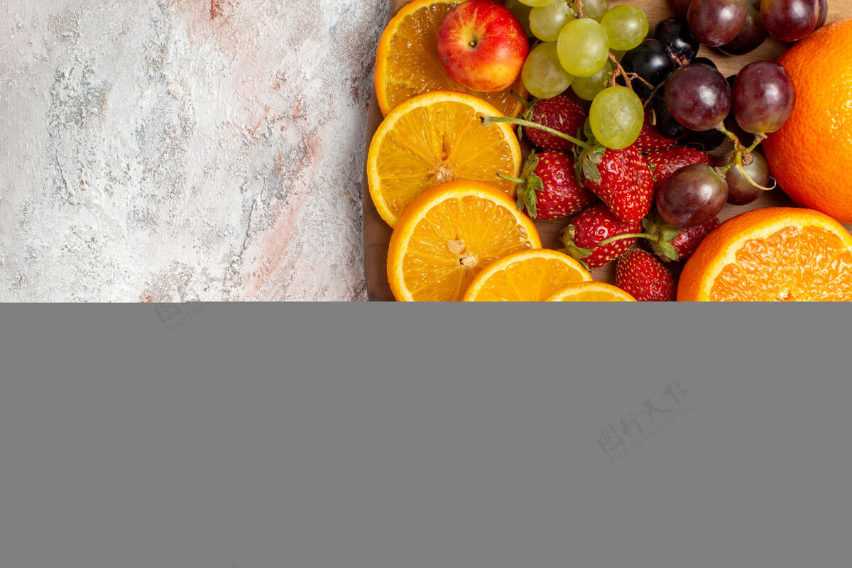 清淡浅白色表面上的新鲜水果 橙子 葡萄和草莓的俯视图多汁可食水果水果