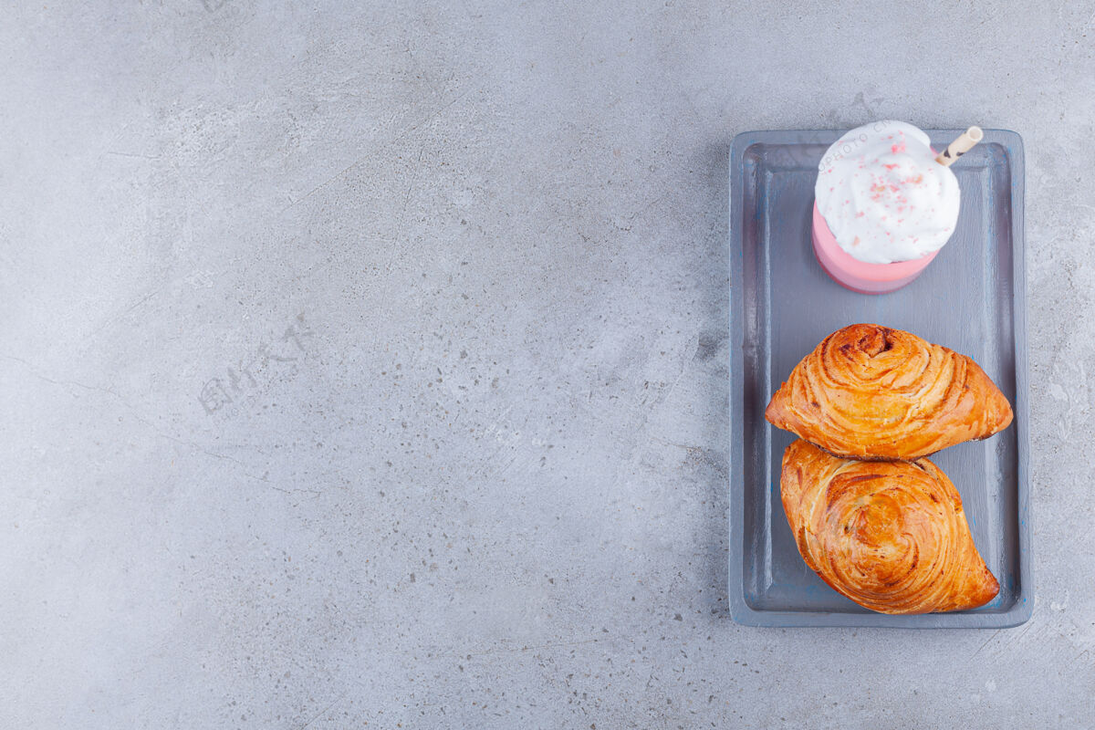顶视图草莓冰沙和两个新鲜糕点放在石头桌上两个冰沙草莓