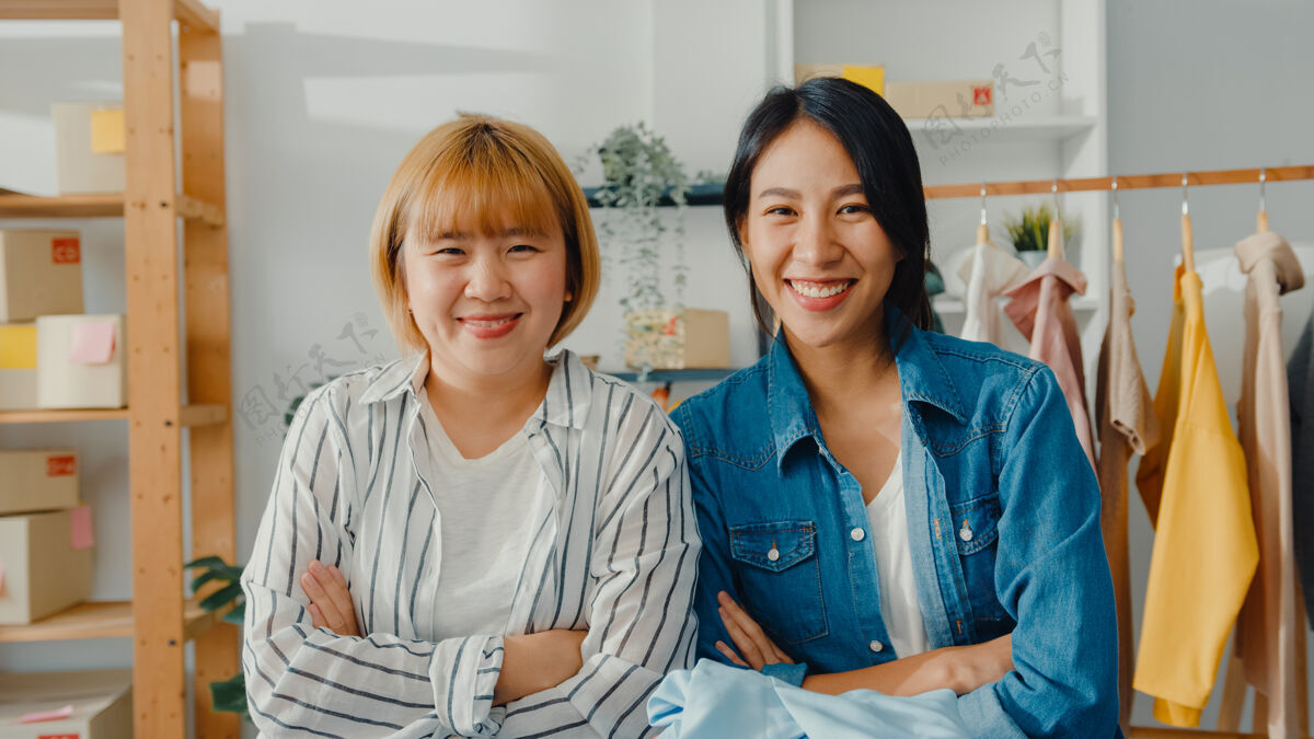 年轻人年轻的亚洲女时装设计师的画像 带着快乐的微笑 双臂交叉 看着前方 同时在家里的服装店工作送货成功亚洲人