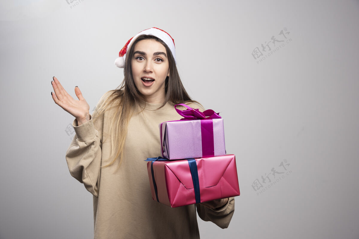 盒子年轻女子拿着两盒圣诞礼物礼物成人表情