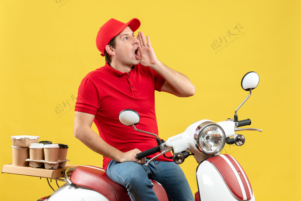 命令顶视图的情绪年轻人穿着红色衬衫和帽子传递命令呼吁黄色背景的人年轻人人交付