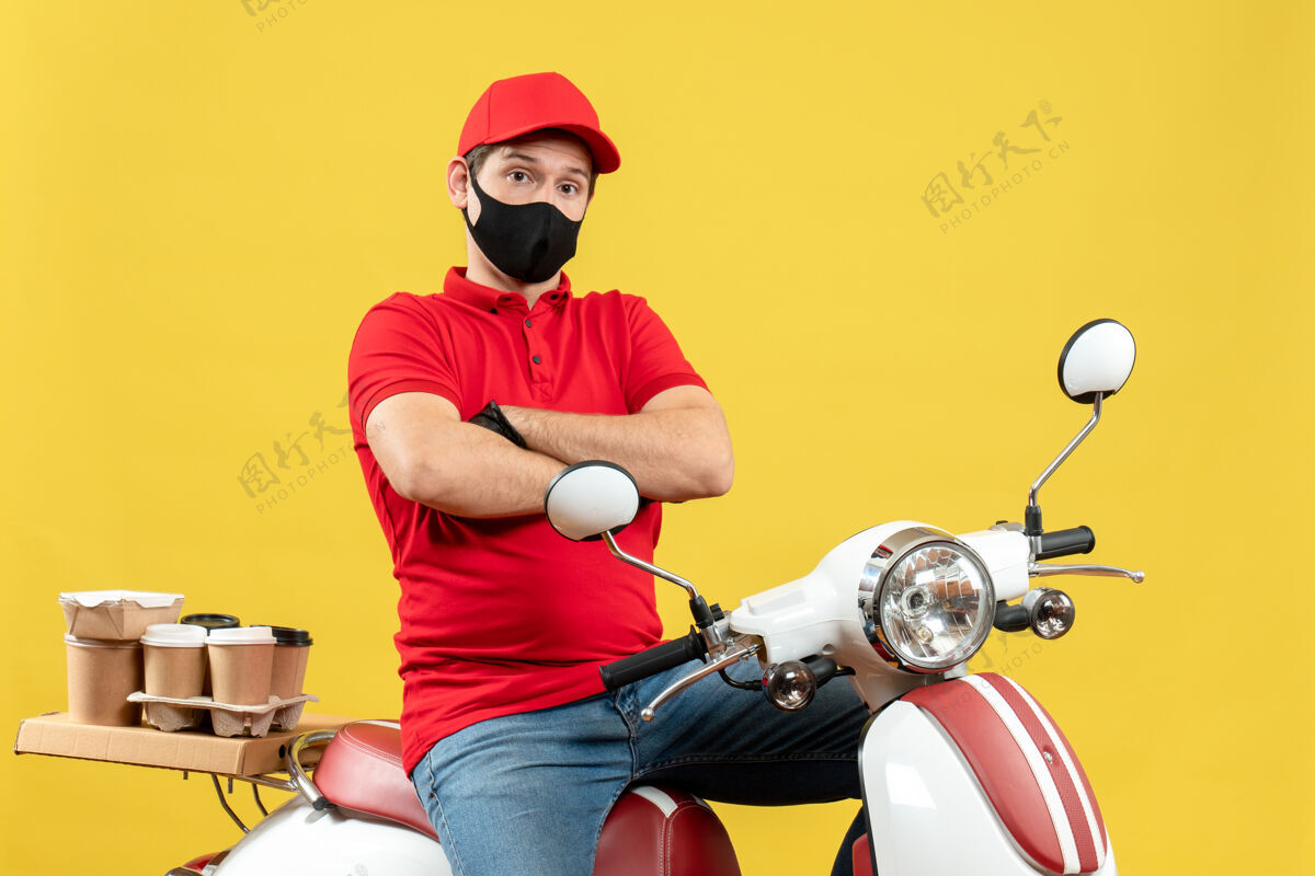 面罩顶视图自信的信使家伙穿着红色上衣和帽子手套在医疗面罩传递命令坐在滑板车上人人命令