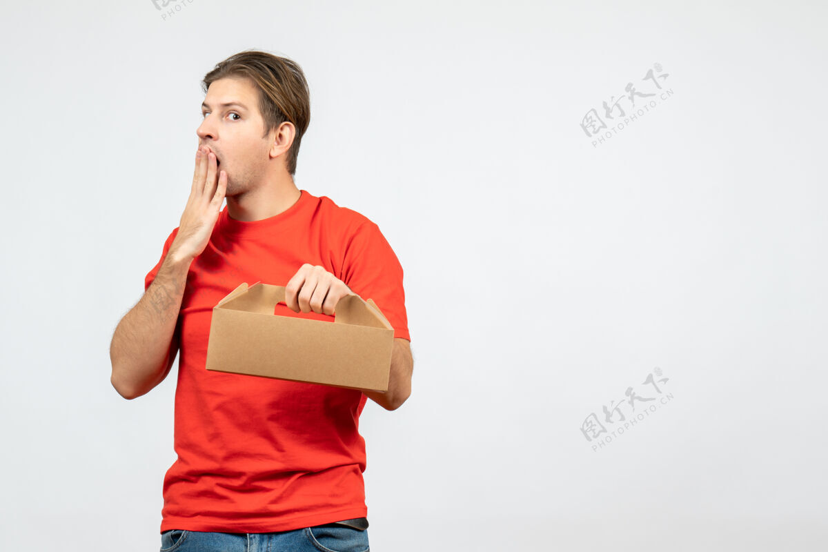 盒子顶视图困惑和情绪化的年轻人在红色衬衫举行的白色背景框肖像背景人物
