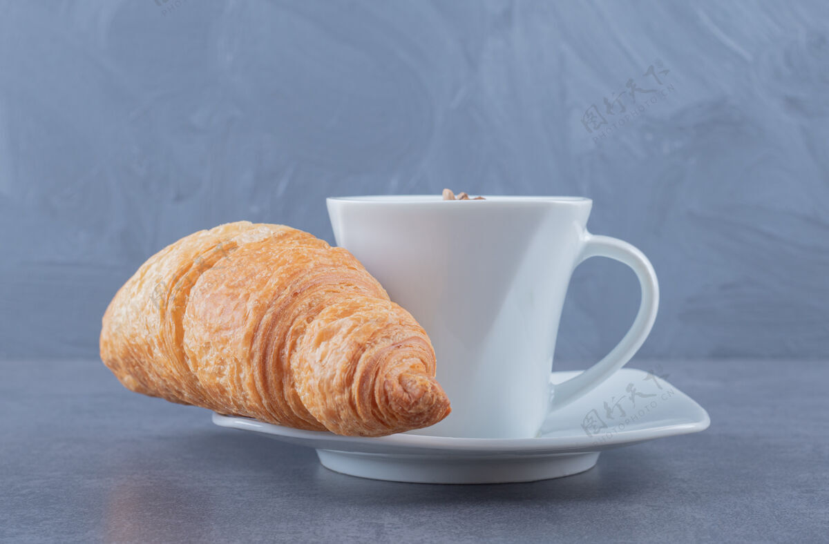 Instagram牛角包配一杯茶灰色背景摩卡咖啡黑暗早晨