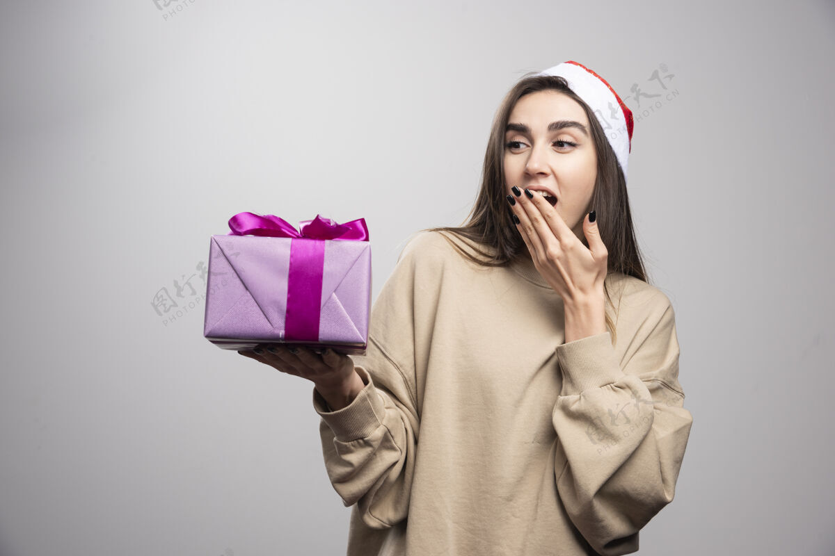 年轻微笑的女人看着一盒圣诞礼物圣诞老人兴奋礼物