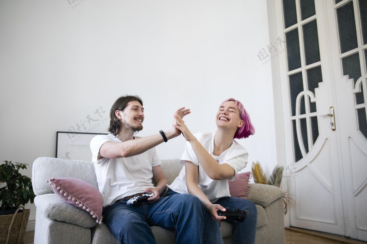 乐趣可爱的情侣在室内玩电子游戏数字娱乐玩家