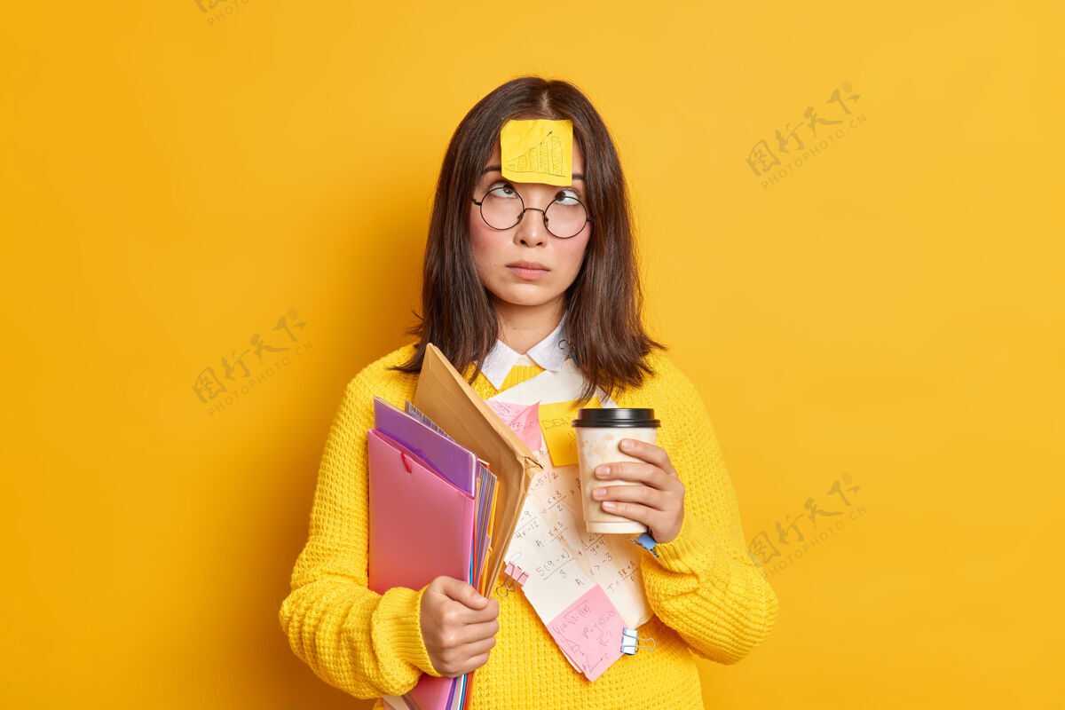教育有趣的女书呆子学生交叉眼睛有粘在额头上的便条有咖啡休息 而准备考试很多工作要做持有文件夹和文件搞笑考试贴纸