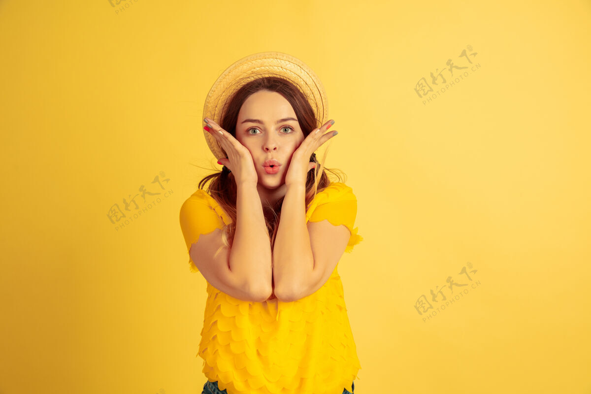 度假村惊讶 震惊 可爱黄色工作室背景上的白种女人肖像戴帽子的漂亮女模特人类情感的概念 面部表情 销售 广告夏季 旅游 度假一半公司成功