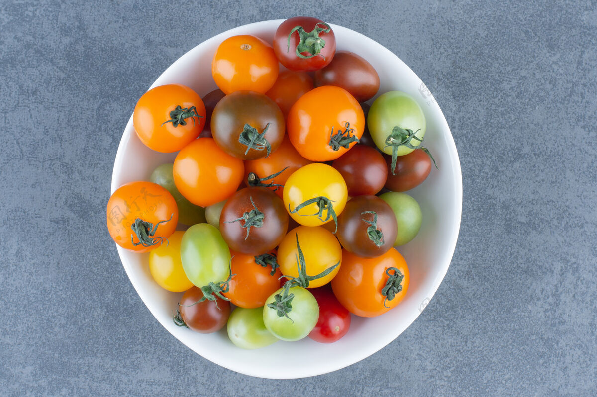 美味白碗里有一堆五颜六色的西红柿成熟的樱桃番茄