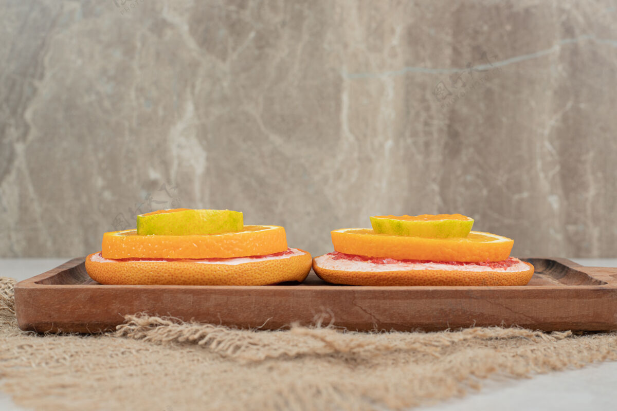 美味新鲜的柑橘水果片放在木板上美味粗麻布切片