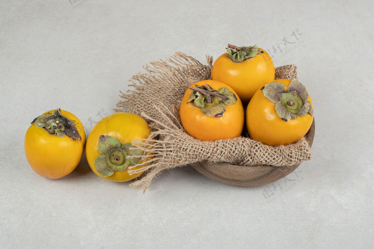 四季一堆熟了的美味柿子放在木碗里新鲜热带美味