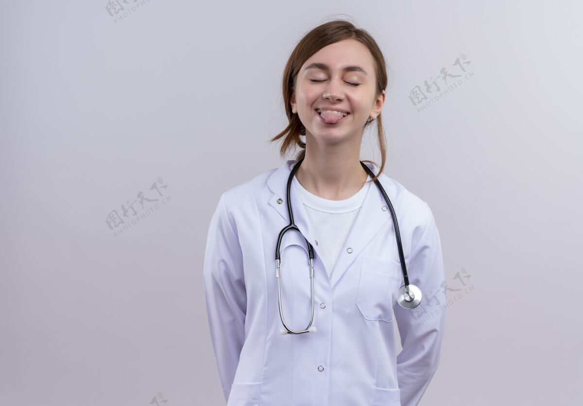 长袍俏皮的年轻女医生 穿着医用长袍 听诊器 闭着眼睛看舌头 留着复印空间表演年轻医生
