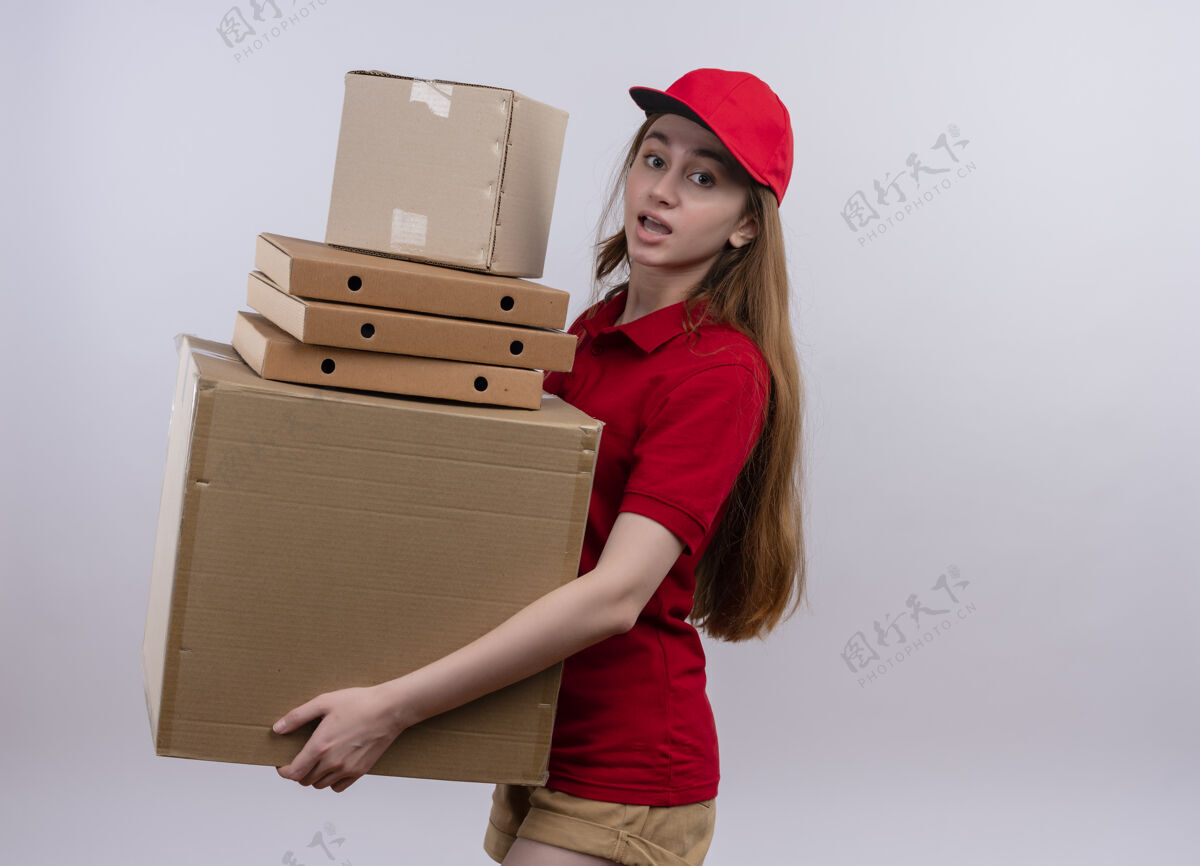 交付令人印象深刻的年轻送货女孩在红色制服举行包裹和箱子上孤立的白色空间与复印空间红色印象空间