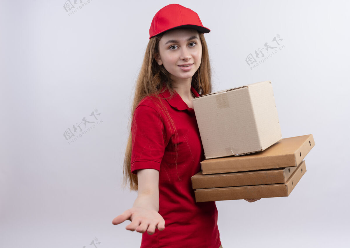 女孩身着红色制服 面带微笑的年轻送货员 手拿着盒子和包裹 手伸向孤立的空白处 还有复印空间手红色复制