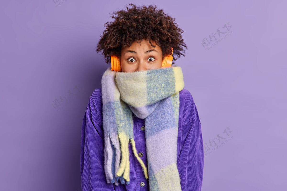 美丽快乐的少女 卷发裹着围巾 冬日闲暇时在户外散步 聆听悦耳的旋律紫色播放列表情感