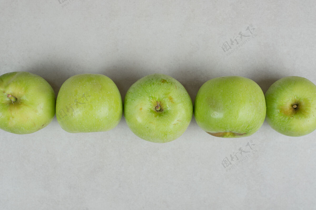 生的整个青苹果在灰色的表面上配料可口熟的