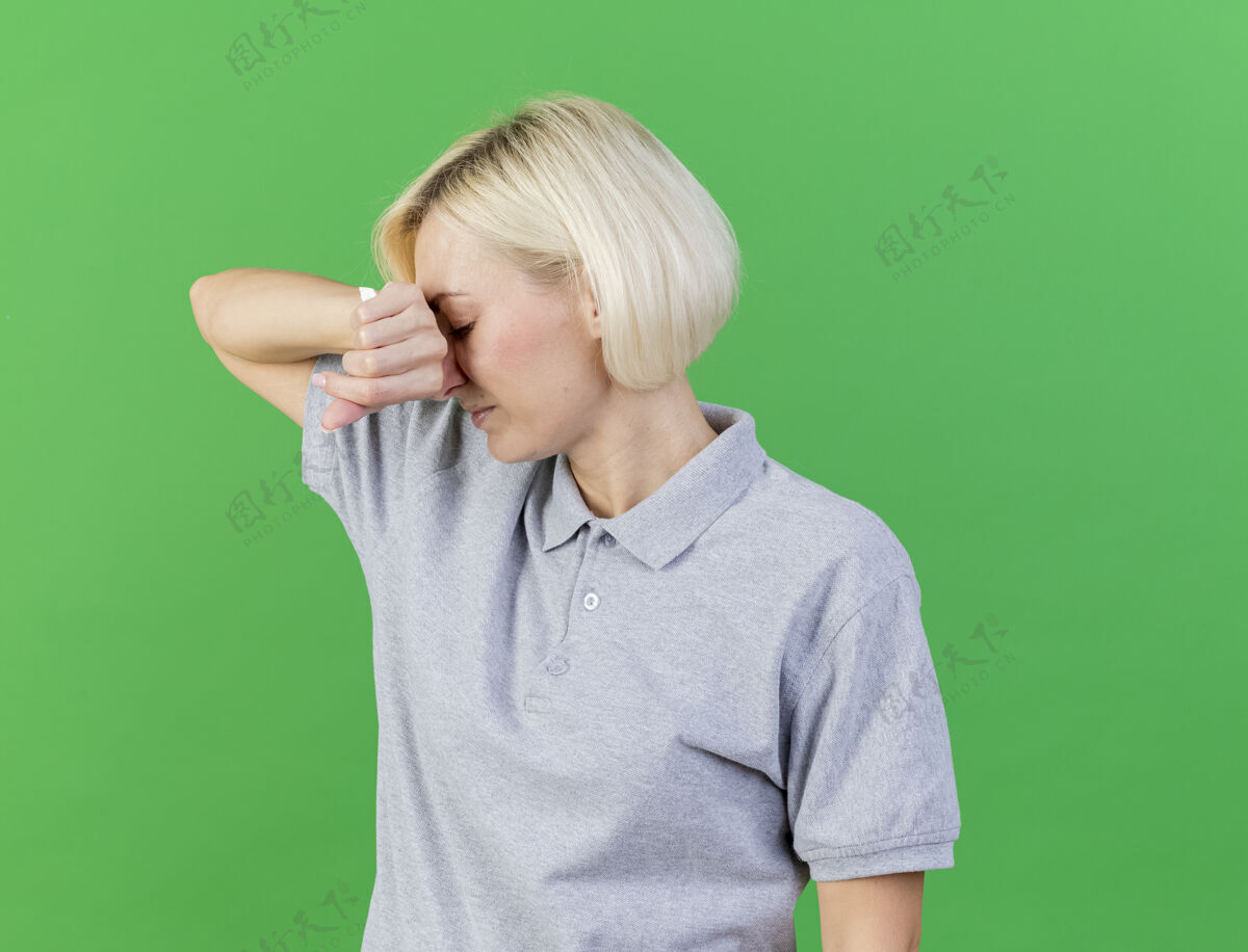组织疼痛的年轻金发病斯拉夫女人把手放在脸上拿着隔离在绿色墙壁上的复印空间组织疾病年轻疼痛