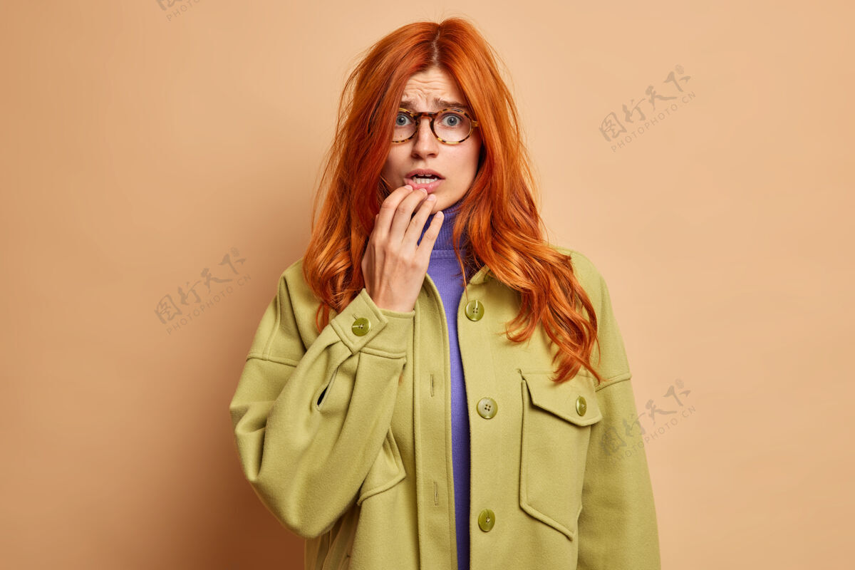 夹克迷惑不解紧张的欧洲女人 姜黄色头发 心急如焚的样子 穿着时髦的夹克女人眼镜担心