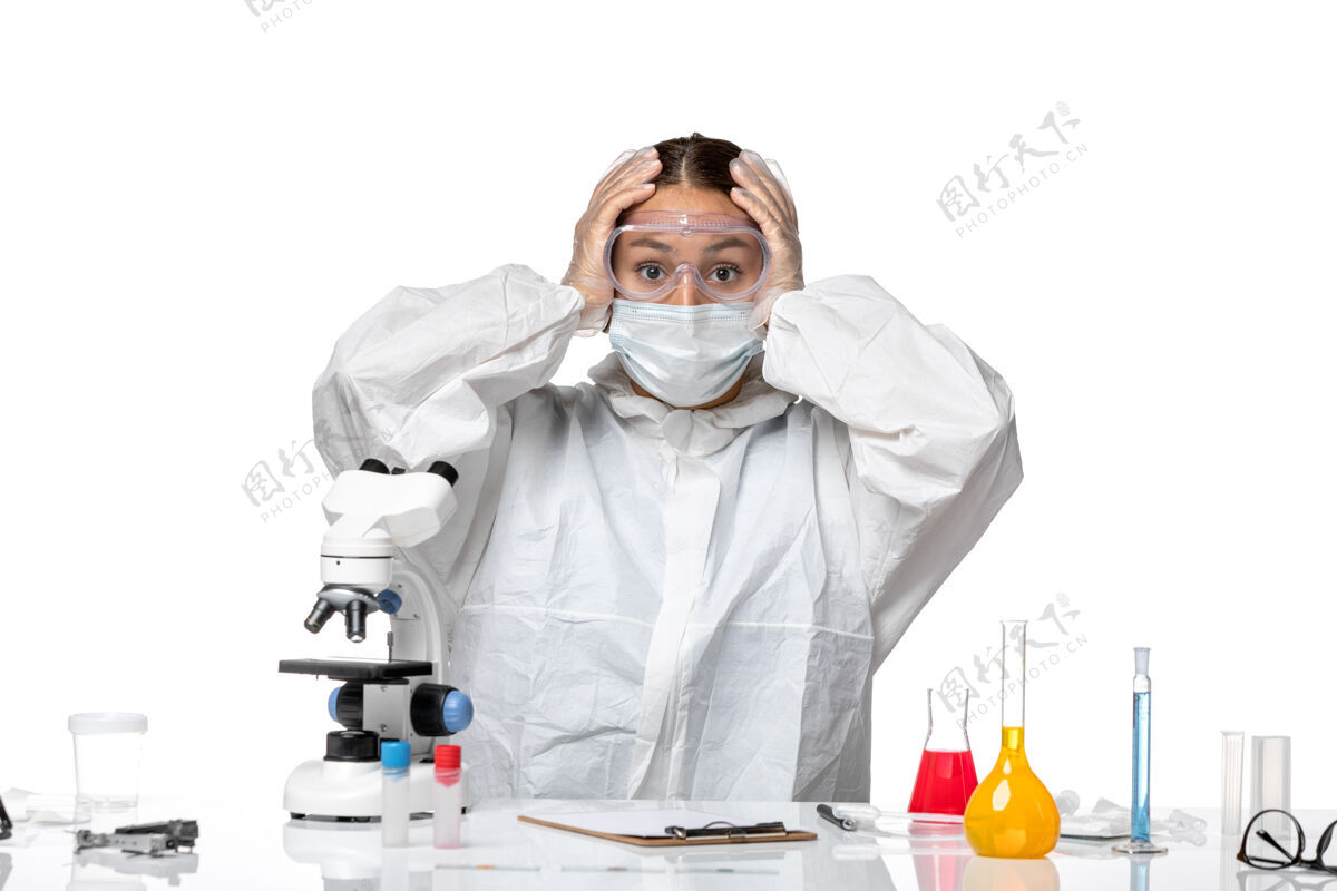 大流行正面图女医生穿着防护服 戴着口罩坐在浅白的背景上 冠状病毒大流行健康冠状病毒实验室外套正面成人