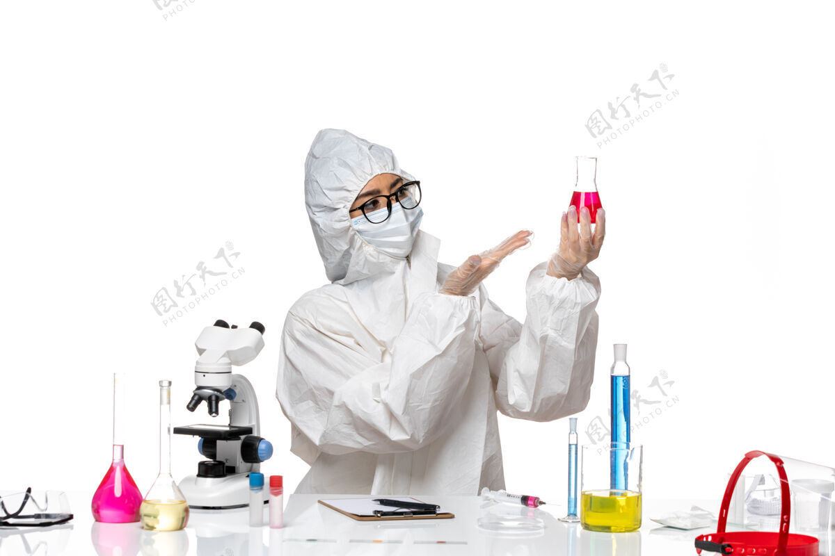 科学前视图穿着特殊防护服的女化学家拿着浅白色背景上的红色溶液-化学病毒实验室女化学家套装医疗