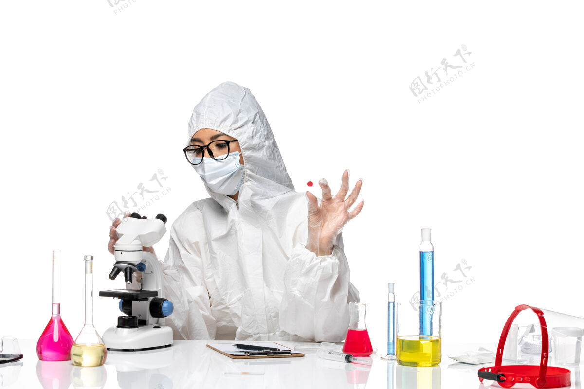 工作前视图穿着特殊防护服的女化学家正在检查白色背景上的样本化学冠状病毒-大流行性健康病毒人病毒健康