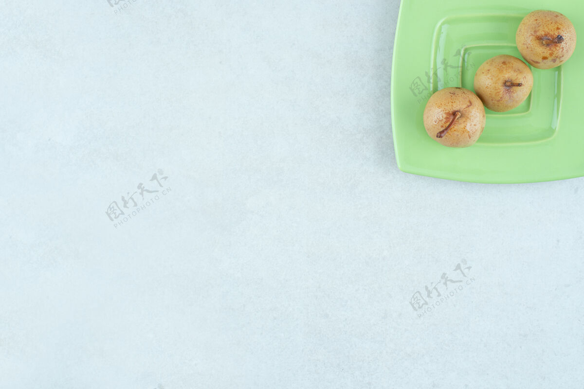 平面自制的腌水果放在绿盘子里泡菜背景水果