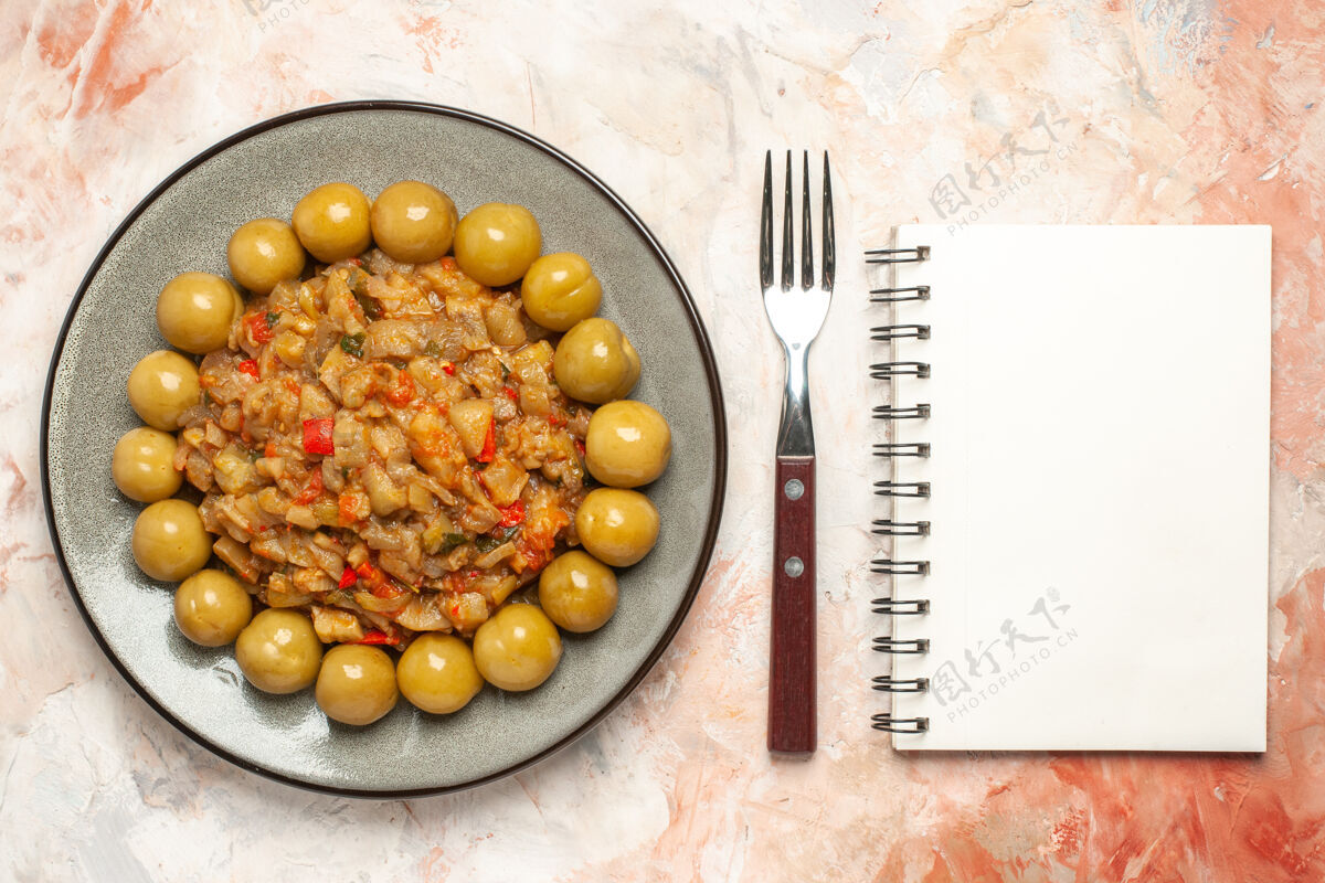 营养烤茄子沙拉和腌李子在盘子叉上的俯视图裸体表面上的笔记本饮食食物裸体