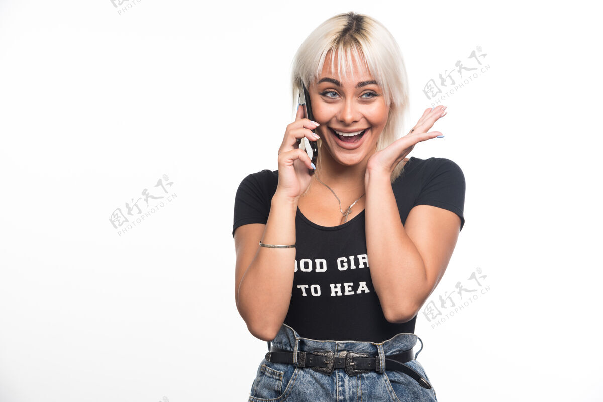 女人快乐的女人在白墙上打电话金发成人积极