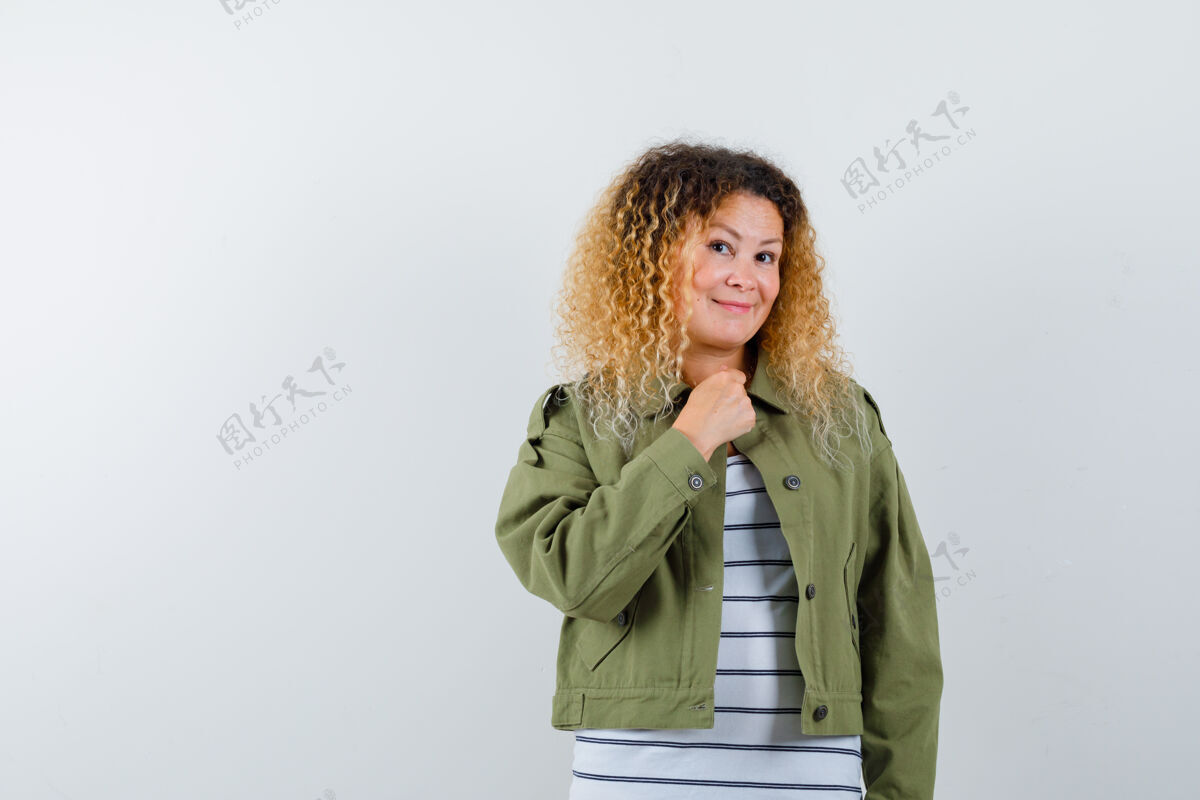 胸脯穿着绿色夹克的成熟女性 t恤手放在胸前 看起来很开朗 前视图成熟夹克肖像