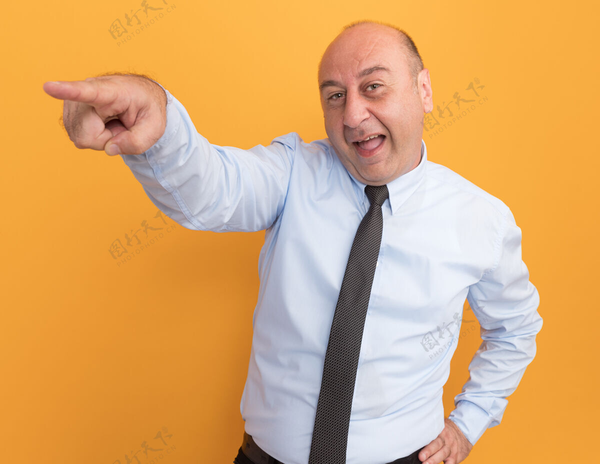 领带快乐的中年男子穿着白色t恤 边上系着领带 手放在腰上 隔离在橙色的墙上公民人感觉