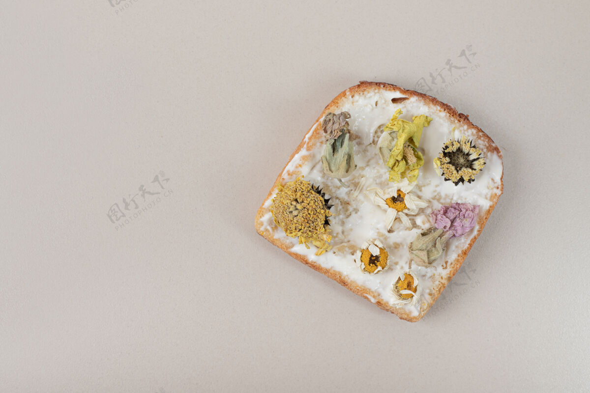 吐司在灰色的桌子上用干花和面粉烤面包面包房美味美味