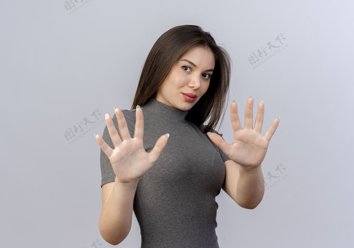 手势年轻漂亮的女人看着相机伸出双手做没有手势的相机隔离在白色背景与复印空间伸展漂亮女人