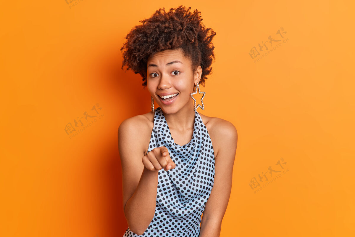 女人我只选你积极的美国黑人女士穿着时髦的衣服 食指直接指向你邀请某人参加聚会 有着独特的橙色背景的时髦发型高兴橙色美国