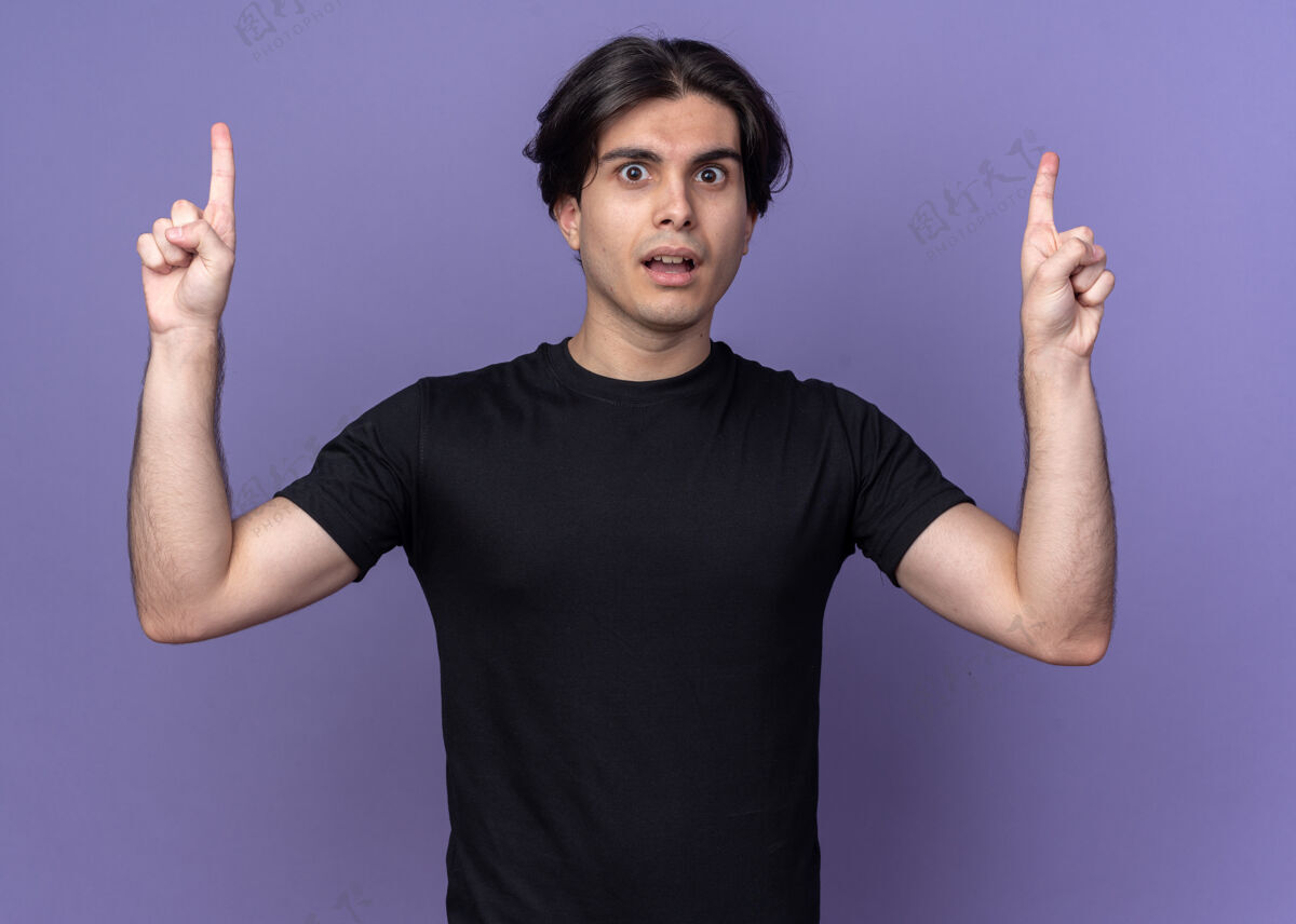 小伙子印象深刻的年轻帅哥穿着黑色t恤点起孤立的紫色墙上年轻点穿着