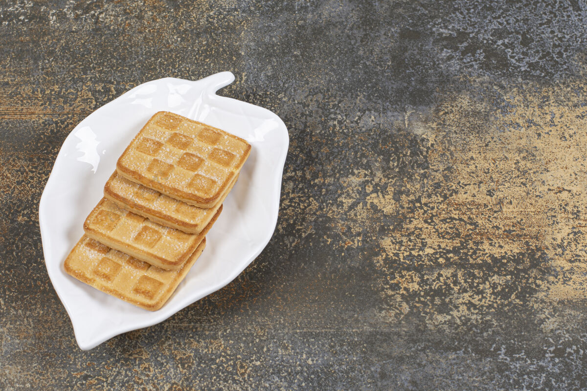 方格叶子形状的盘子上放着方形的甜饼干饼干营养烤的